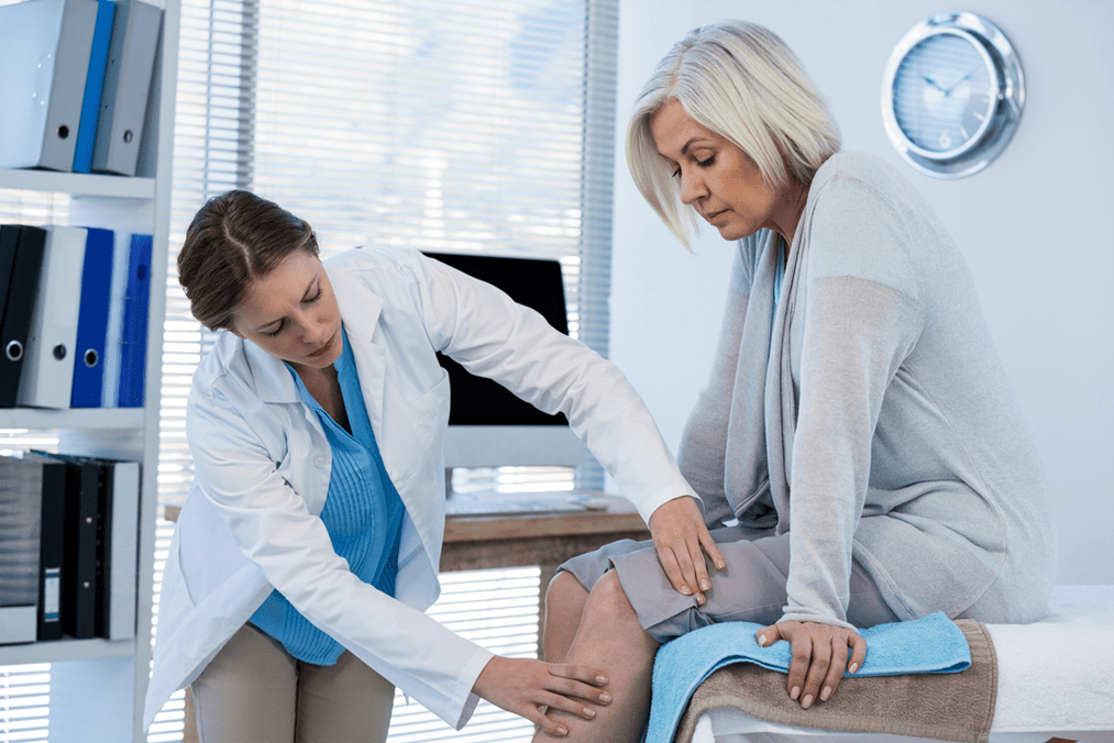 The doctor will examine the patient with arthrosis of the knee joint